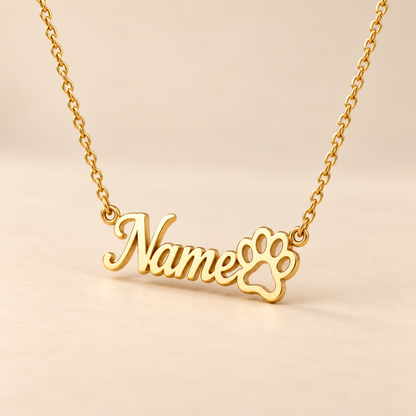 Custom paw print name necklace on warm beige background, angled view