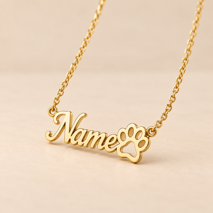 Custom paw print name necklace close-up on warm beige background