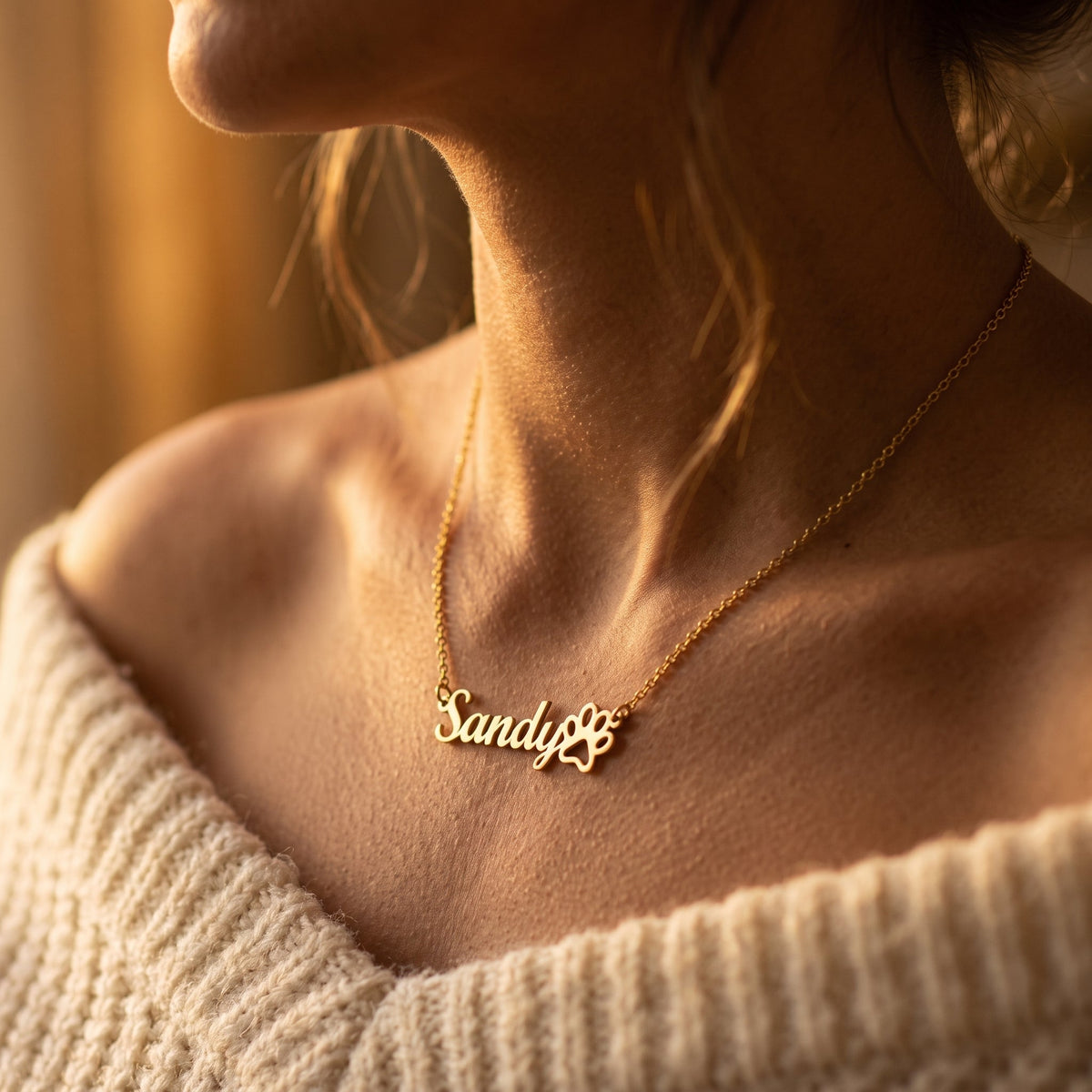 Woman wearing a personalized paw print name necklace